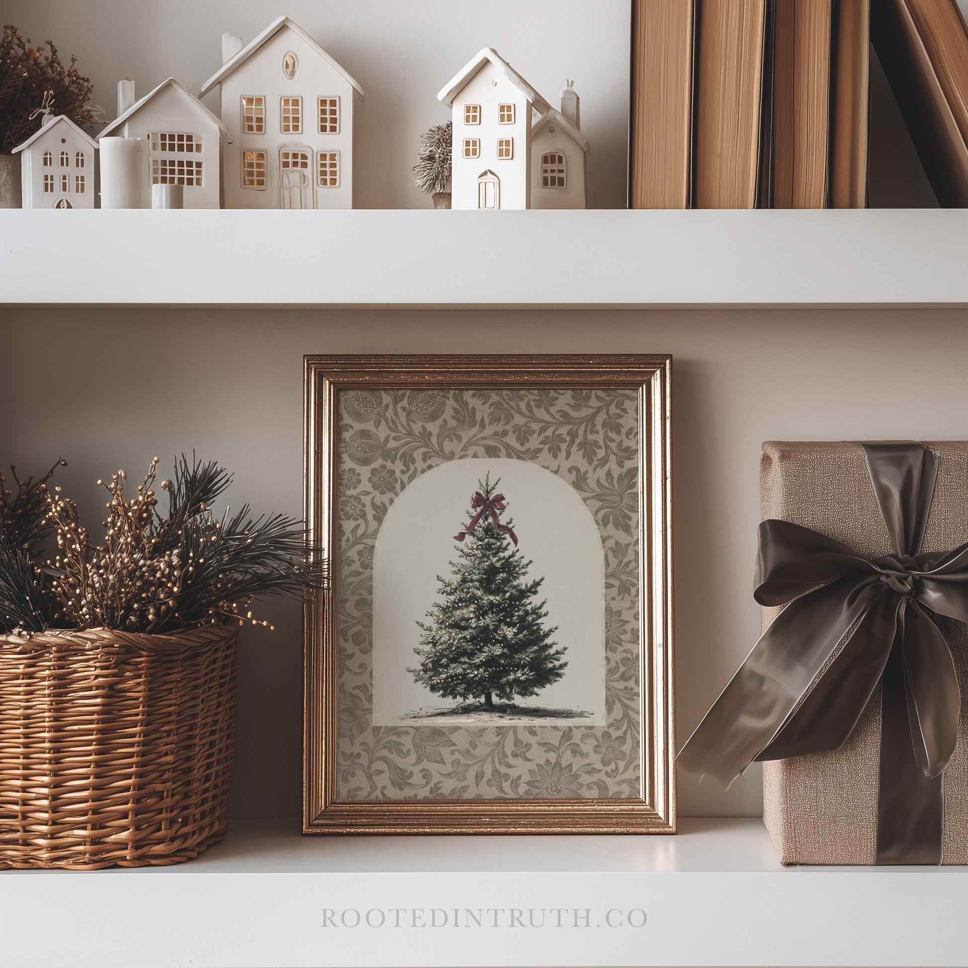 a framed picture of a Christmas tree on a shelf, surrounded by various holiday decorations such as a wicker basket, a gift box with a ribbon, and a small white house model.