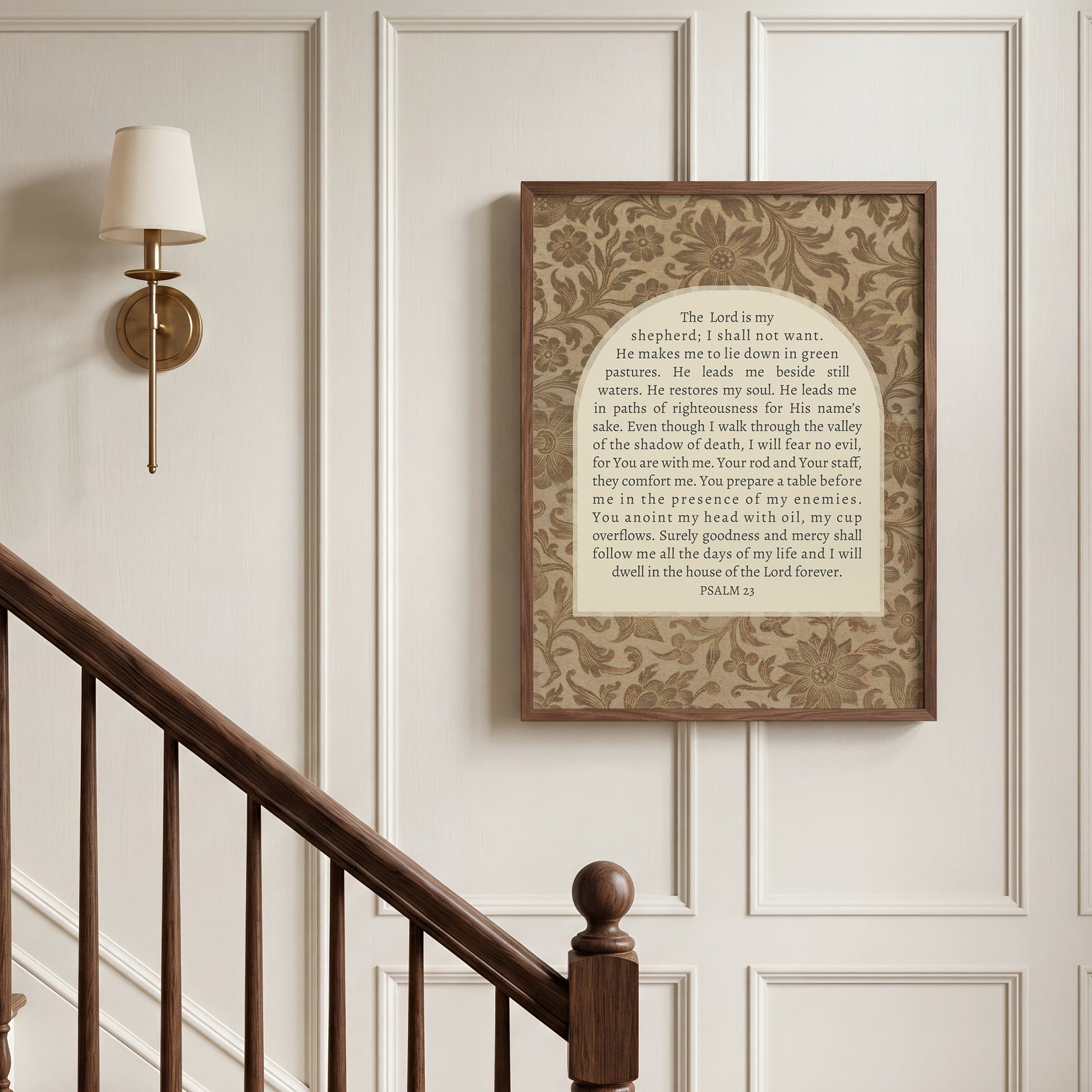 a framed religious text, specifically a passage from the Bible, hanging on a wall next to a wooden staircase.