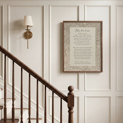 a wooden staircase with a framed text above it, and a wall lamp to the left.