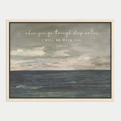 The image is a framed painting depicting a serene ocean scene with a cloudy sky above. The text overlay reads "when you go through deep waters, I will be with you" and is attributed to Isaiah 43:13.