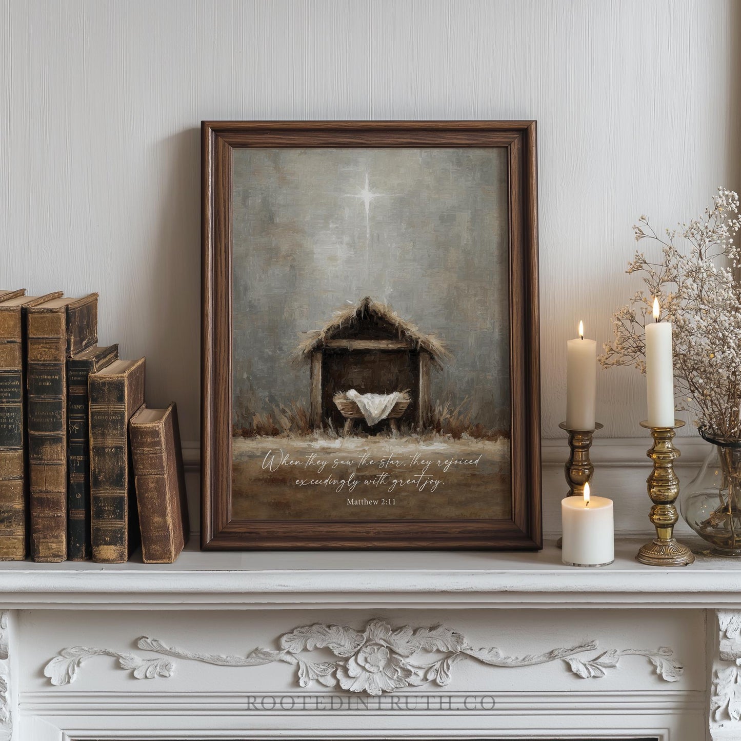a framed painting of a manger with a baby, surrounded by books, candles, and a decorative shelf.