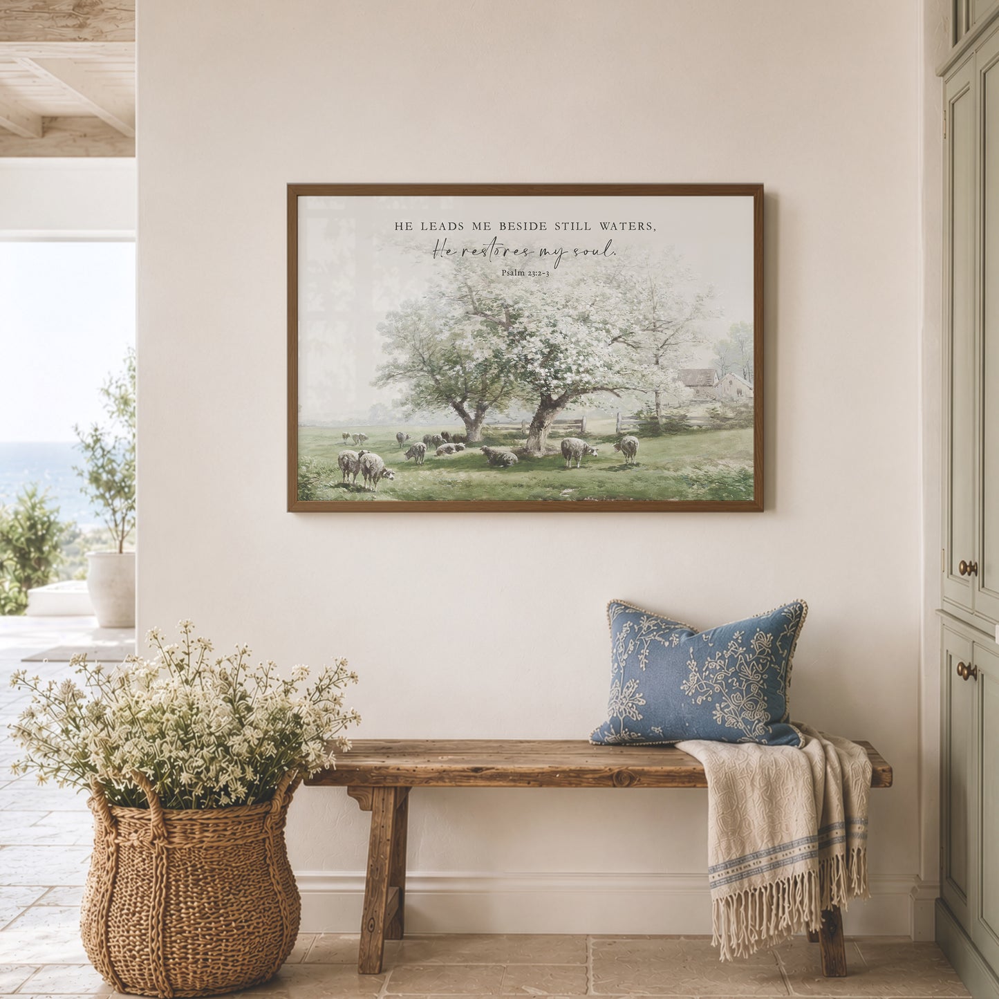 a serene indoor setting with a wooden bench, a woven basket filled with white flowers, and a framed picture of a pastoral scene hanging on the wall.