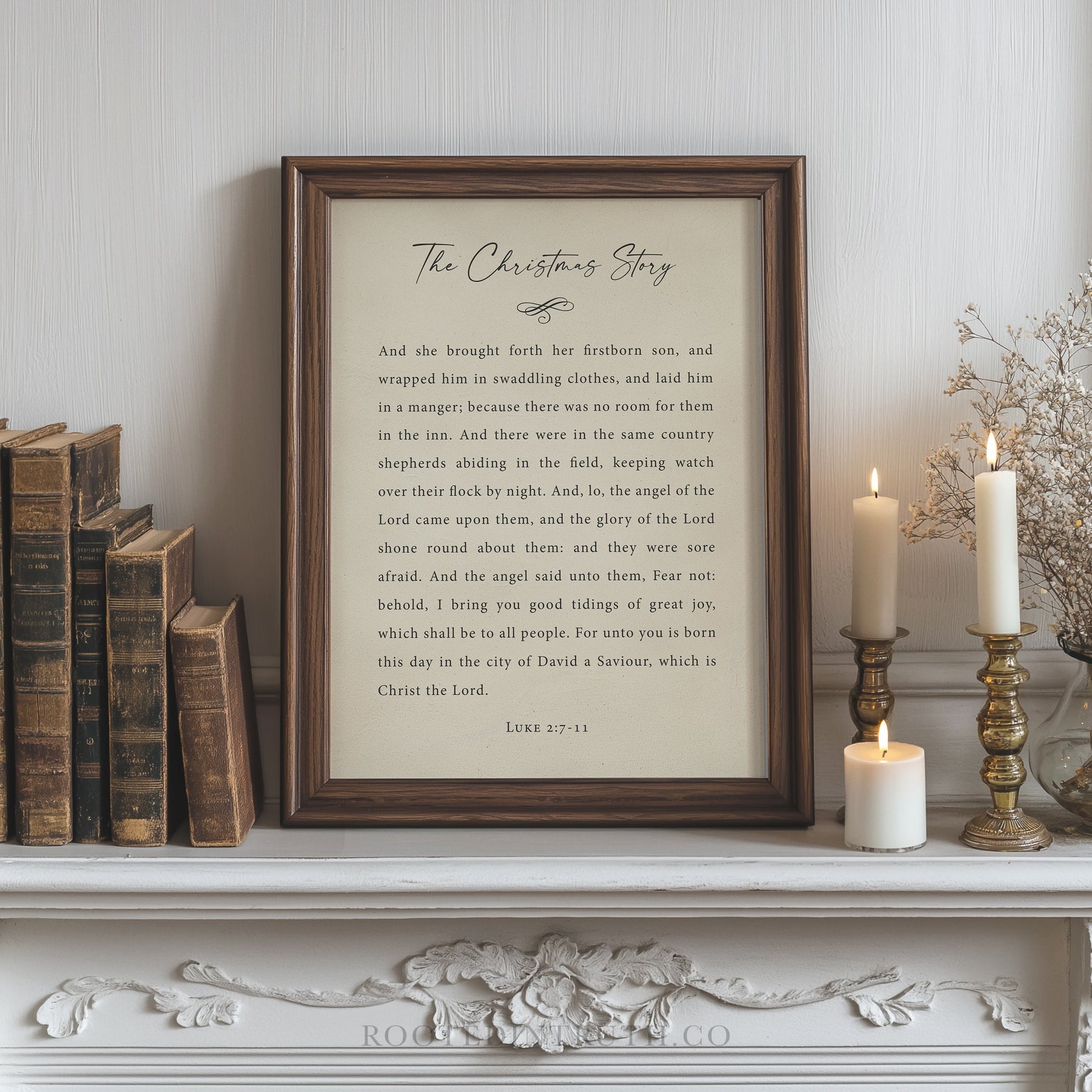a framed text titled "The Christmas Story" displayed on a white shelf, surrounded by a collection of books and candles.