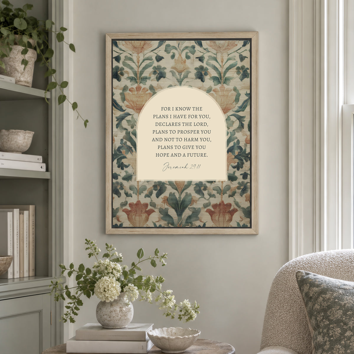 a framed print of a floral pattern hanging on a wall, with a quote from the Bible verse "Bible verse 29:11" below it. The print is surrounded by various decorative elements, such as a vase of flowers, books, and a potted plant.
