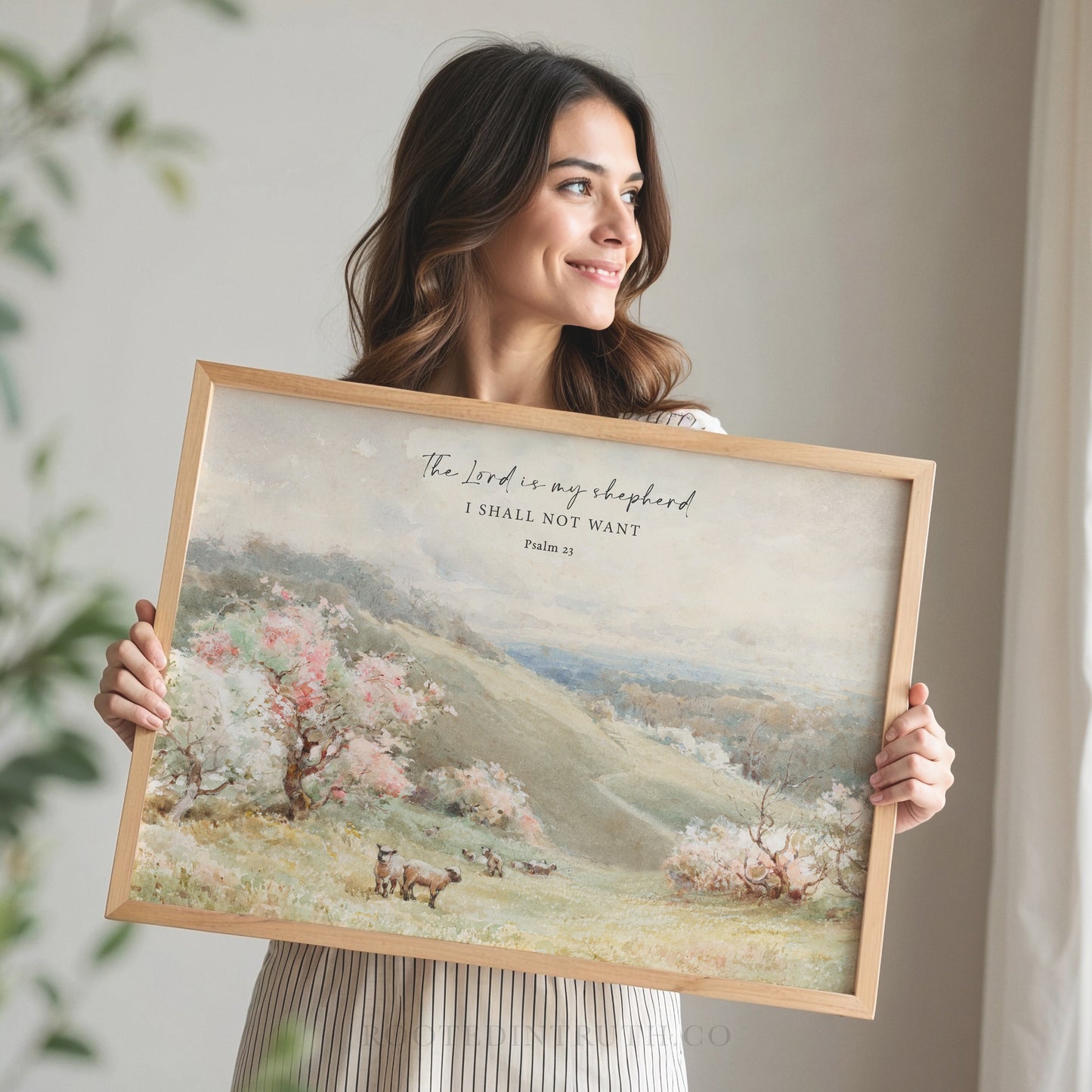 a woman holding up a painting with a quote on it