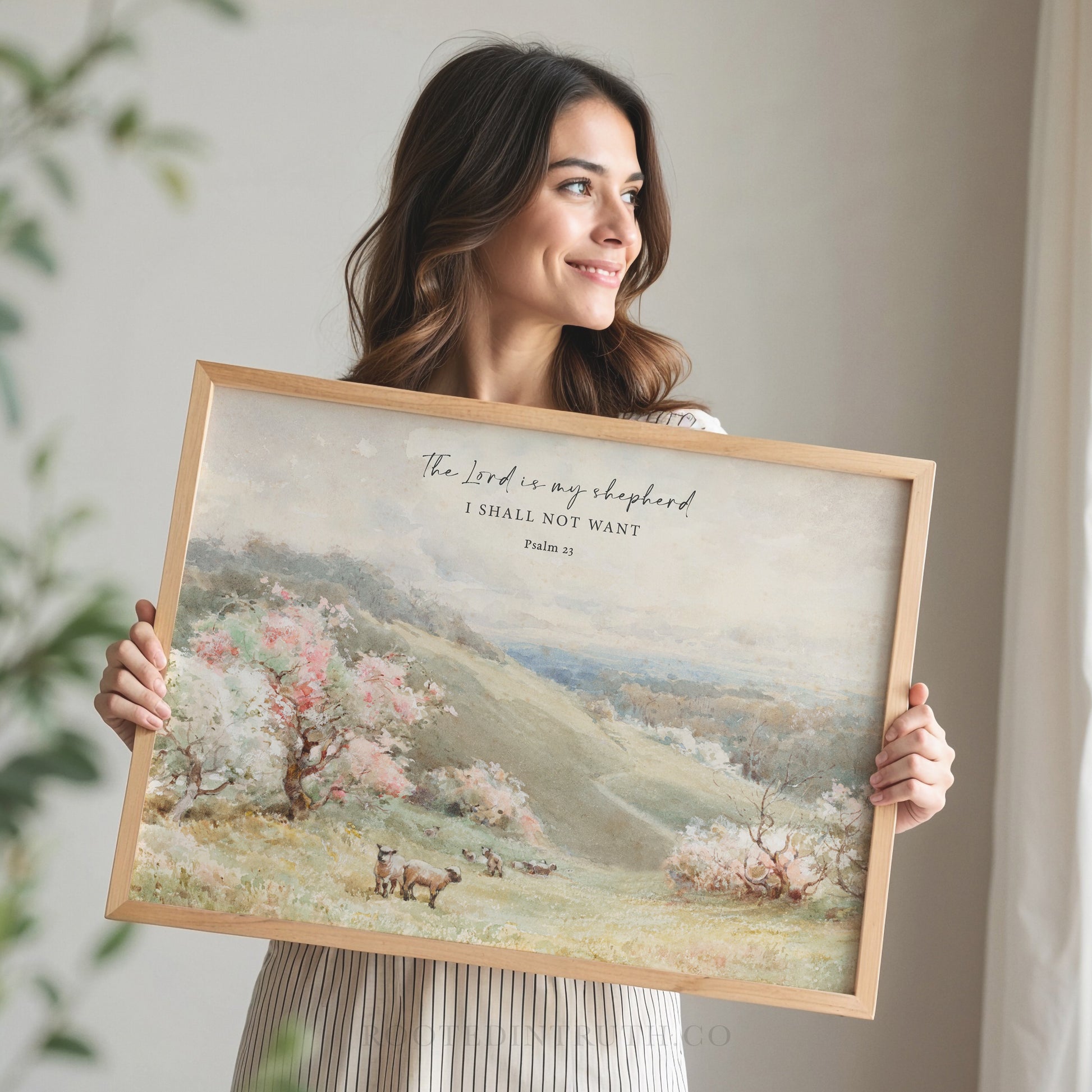 a woman holding up a painting with a quote on it