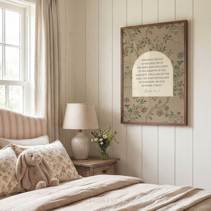 A bedroom with a bed, a lamp, and a framed Bible verse on the wall.