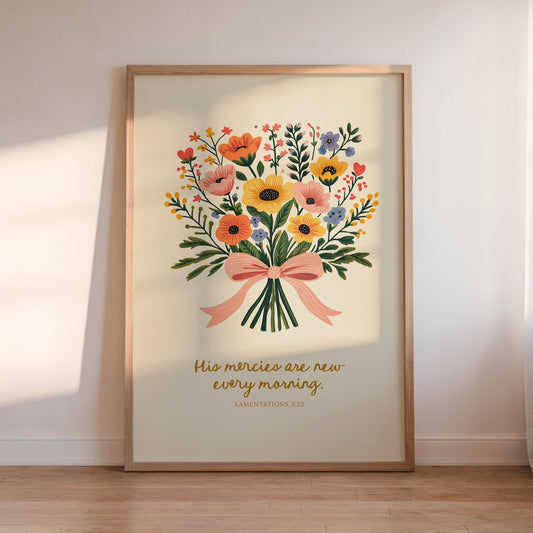 A framed print of a floral bouquet with a text overlay, placed on a wooden floor against a white wall.