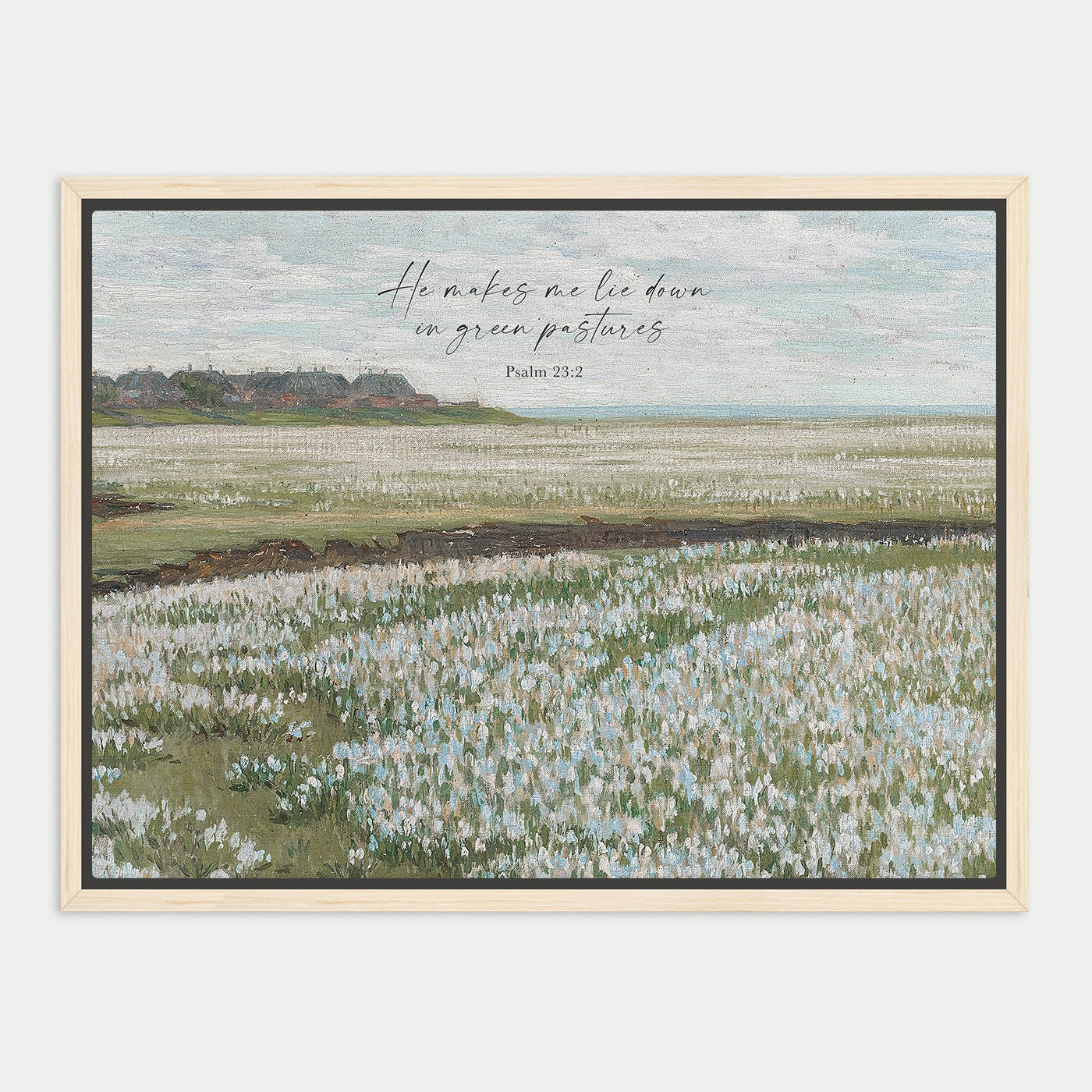 The image is a framed painting depicting a serene landscape with a field of flowers in the foreground and a distant hill in the background. The sky is clear blue with some clouds. The painting is framed in a wooden frame and includes a Bible verse from Psalm 23:2.