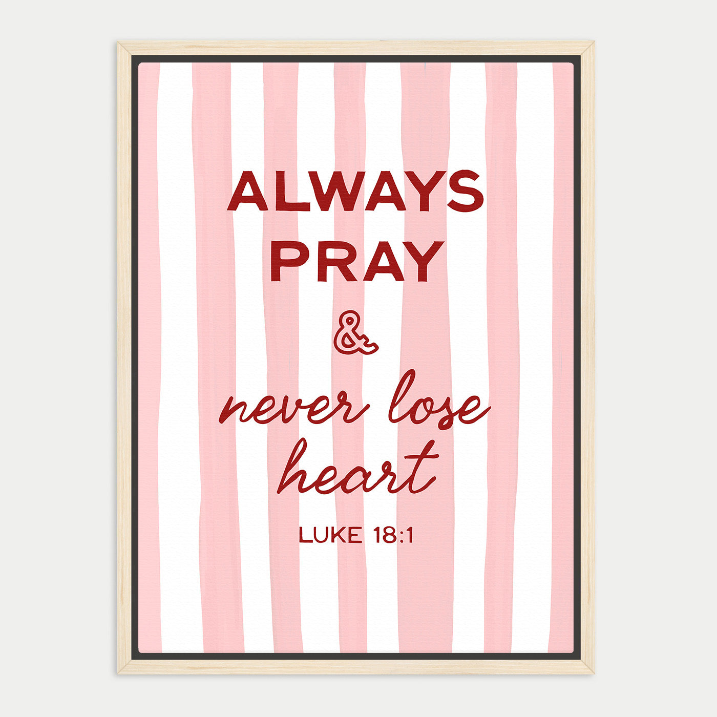 a framed poster with a pink and white striped background. The poster contains a religious quote from the Bible, specifically Luke 18:1, which reads "Always Pray & never lose heart".