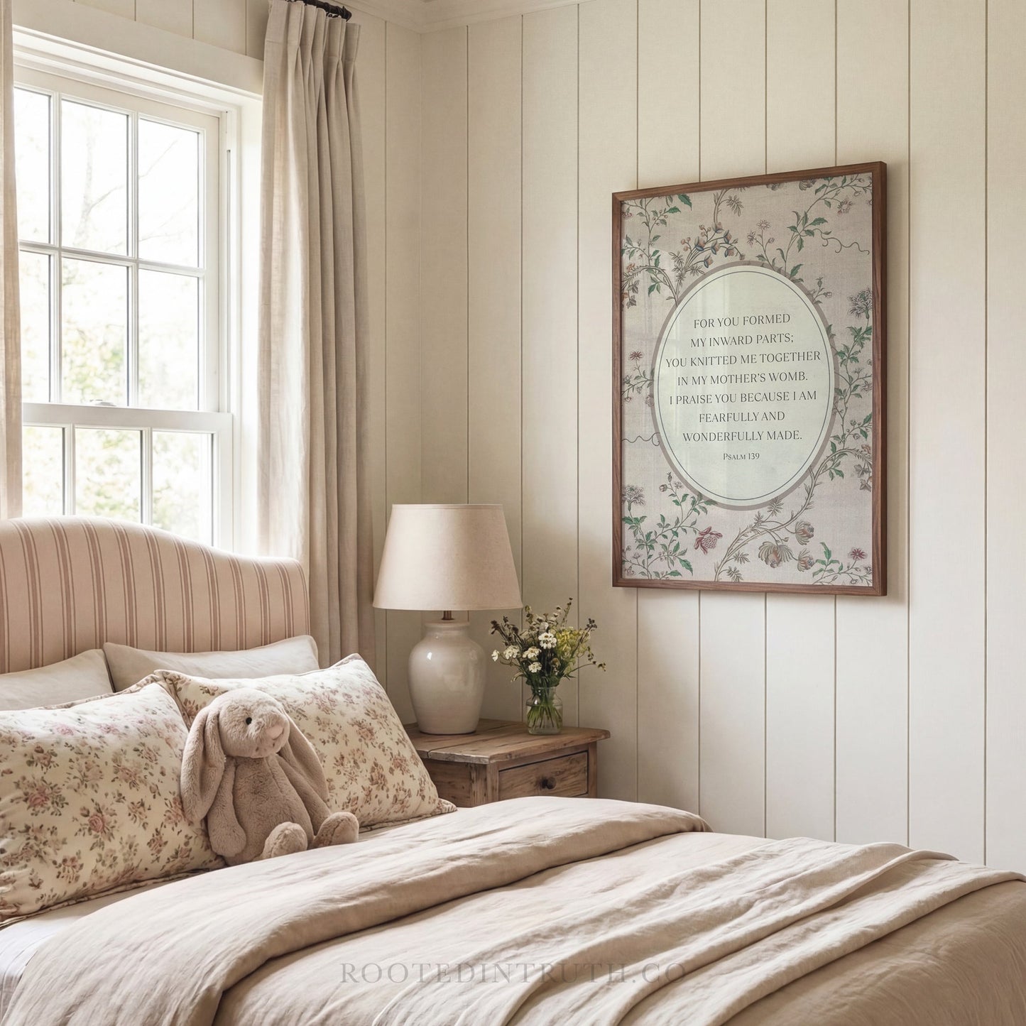 a cozy bedroom scene with a bed, a lamp, a stuffed animal, and a framed quote on the wall.