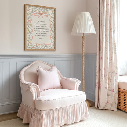 a cozy corner of a room with a pink armchair, a floor lamp, and a framed inspirational quote on the wall.