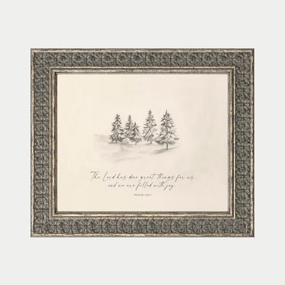 a framed illustration of a snowy landscape with a group of pine trees in the background.