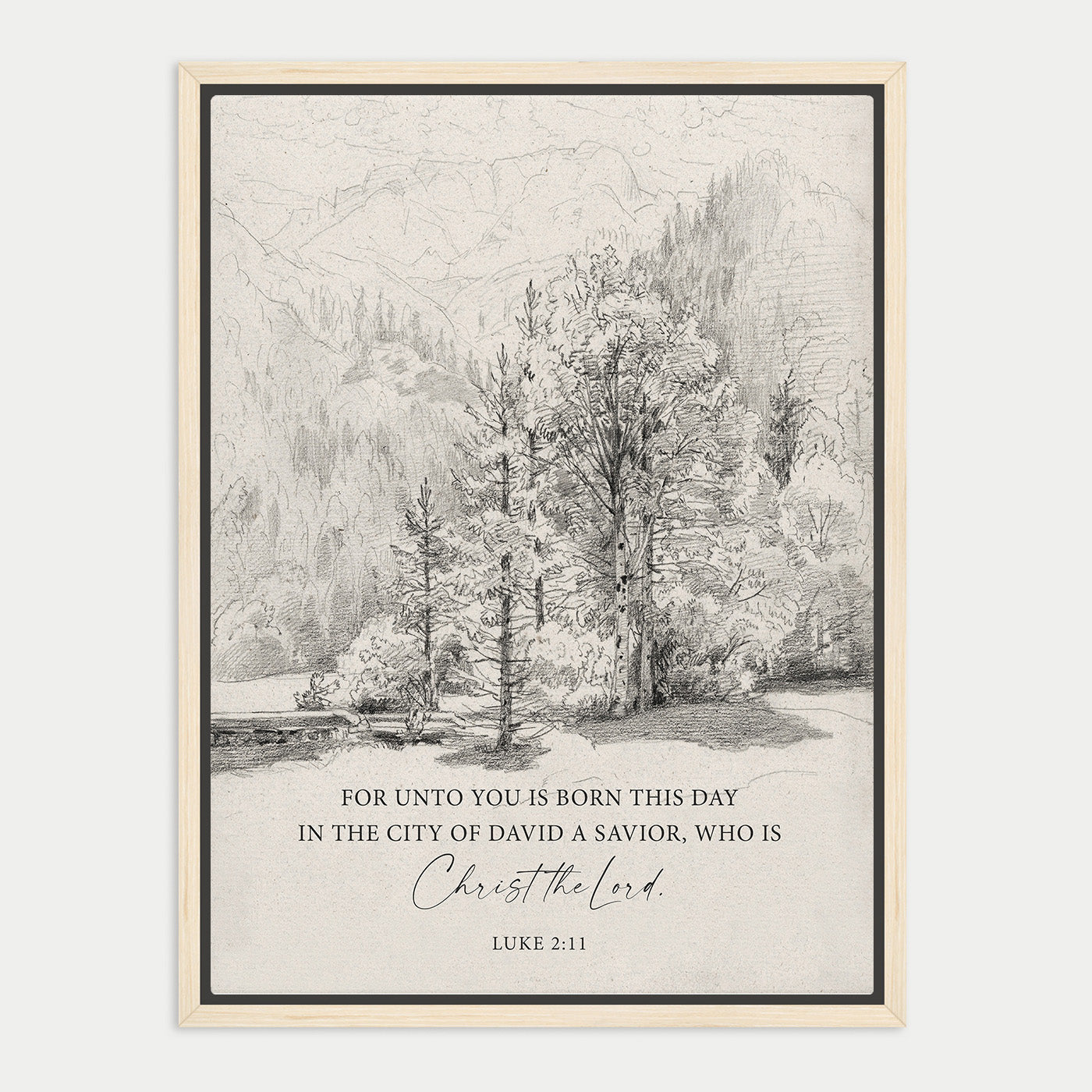 The image is a framed print featuring a black and white illustration of a forest landscape with mountains in the background. The text below the image reads, "FOR UNTO YOU IS BORN THIS DAY IN THE CITY OF DAVID A SAVIOR, WHO IS CHRIST THE LORD. LUE 211".