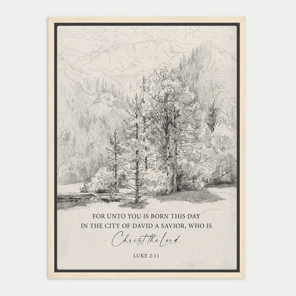 The image is a framed print featuring a black and white illustration of a forest landscape with mountains in the background. The text below the image reads, "FOR UNTO YOU IS BORN THIS DAY IN THE CITY OF DAVID A SAVIOR, WHO IS CHRIST THE LORD. LUE 211".