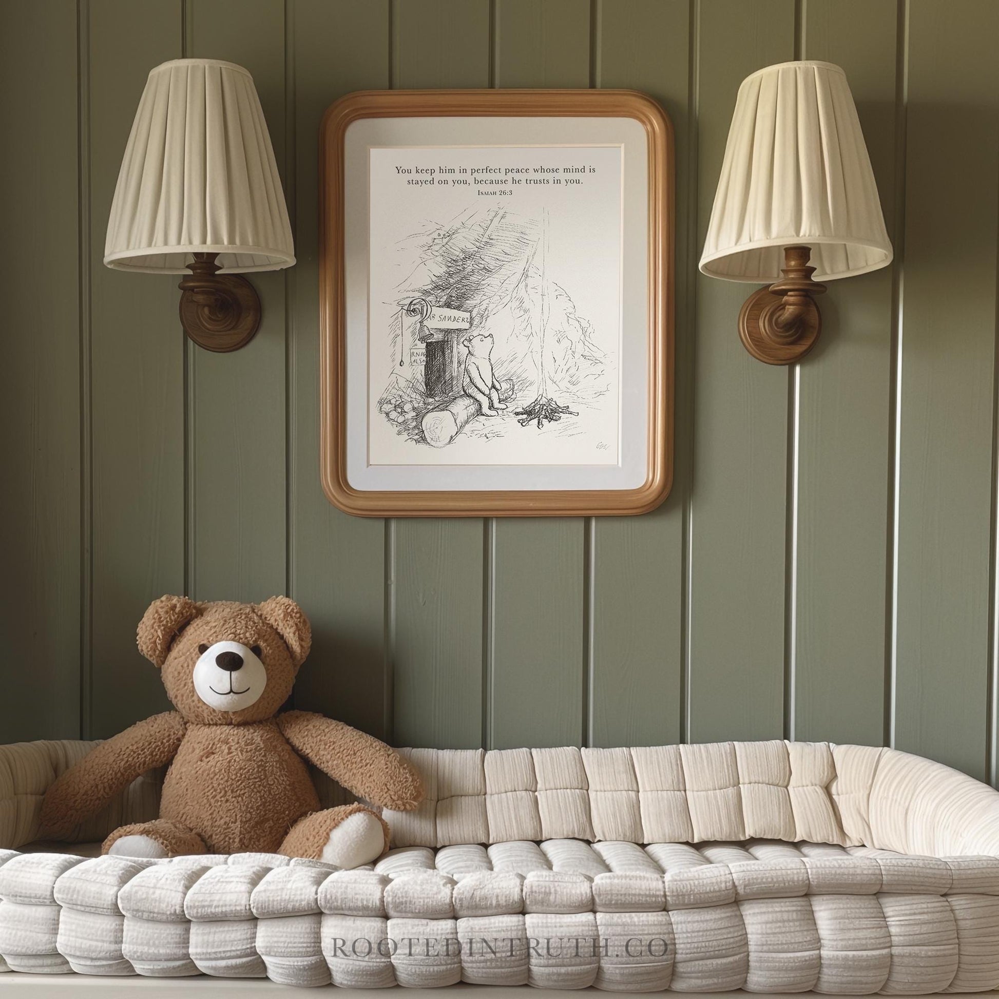 A brown teddy bear sits on a white bed, with a framed picture of a bear and a quote above it, and two wall sconces on either side.