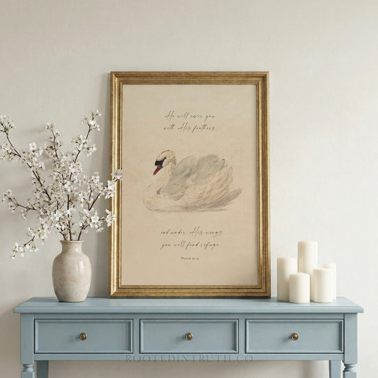 a framed print of a swan on a blue table, accompanied by a vase of white flowers and three white candles.