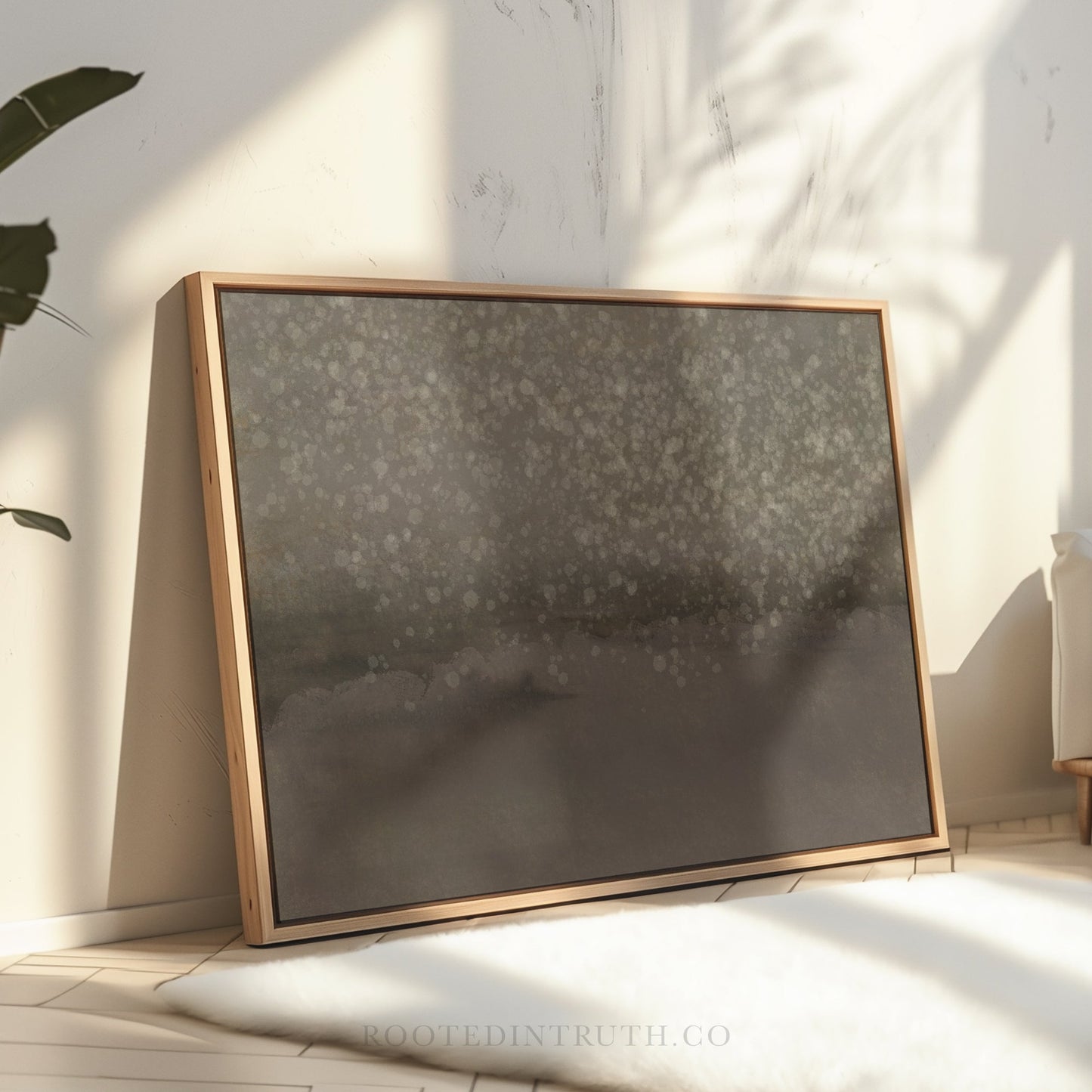 a large, dark-colored painting or artwork displayed on a wooden frame, placed on a white surface against a white wall.