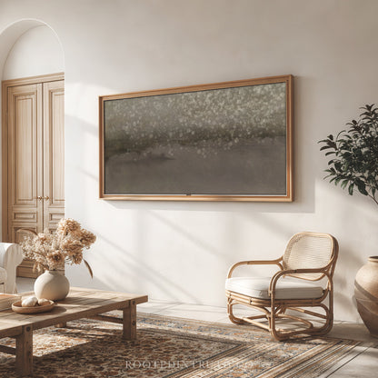 a cozy living room with a large framed artwork hanging on the wall, a wooden coffee table, a woven chair, and a potted plant.