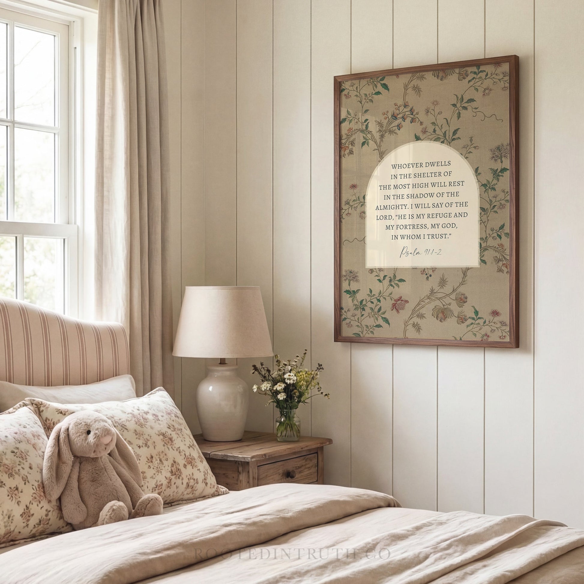 A bedroom with a bed, a lamp, and a framed Bible verse on the wall.