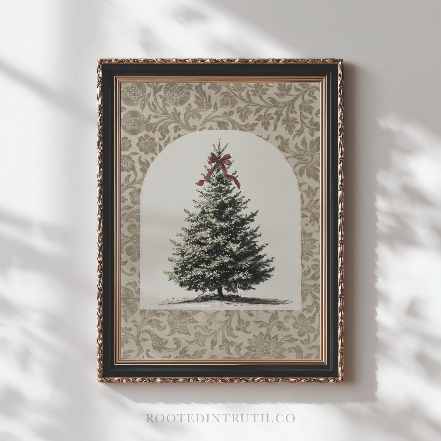 A framed picture of a Christmas tree with a red bow on top, set against a decorative floral background.