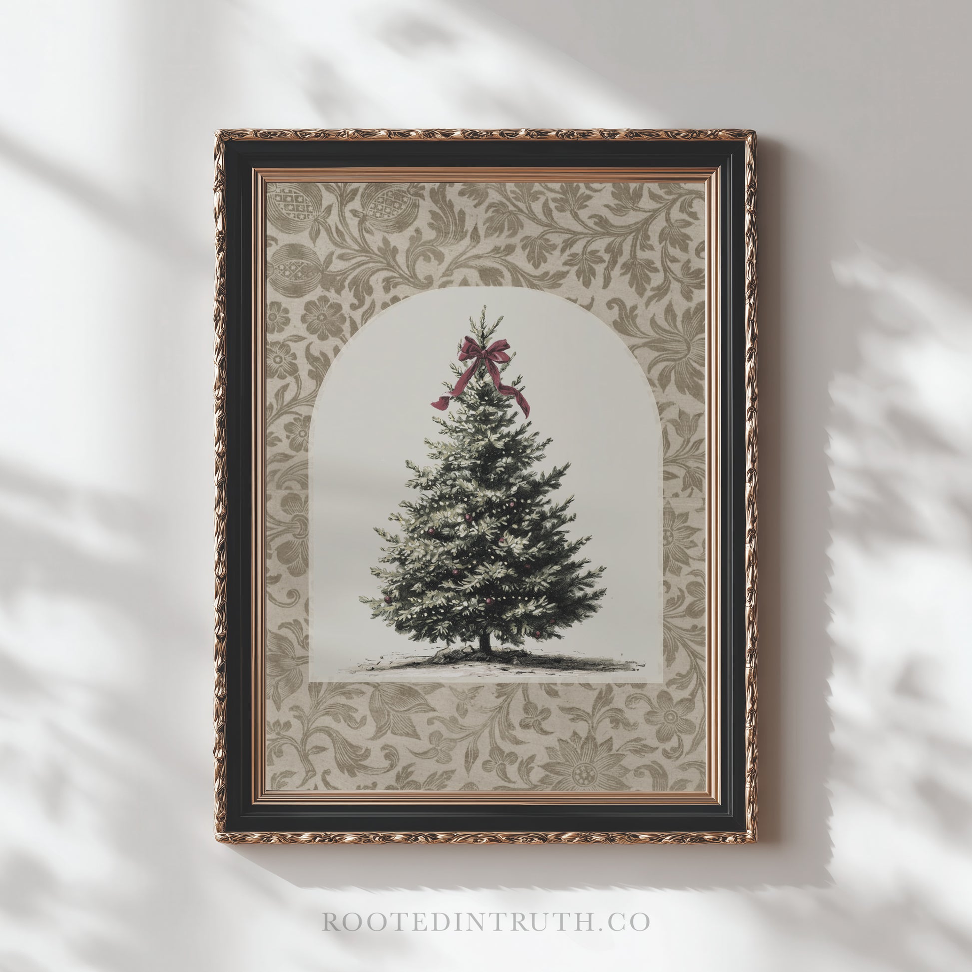 A framed picture of a Christmas tree with a red bow on top, set against a decorative floral background.