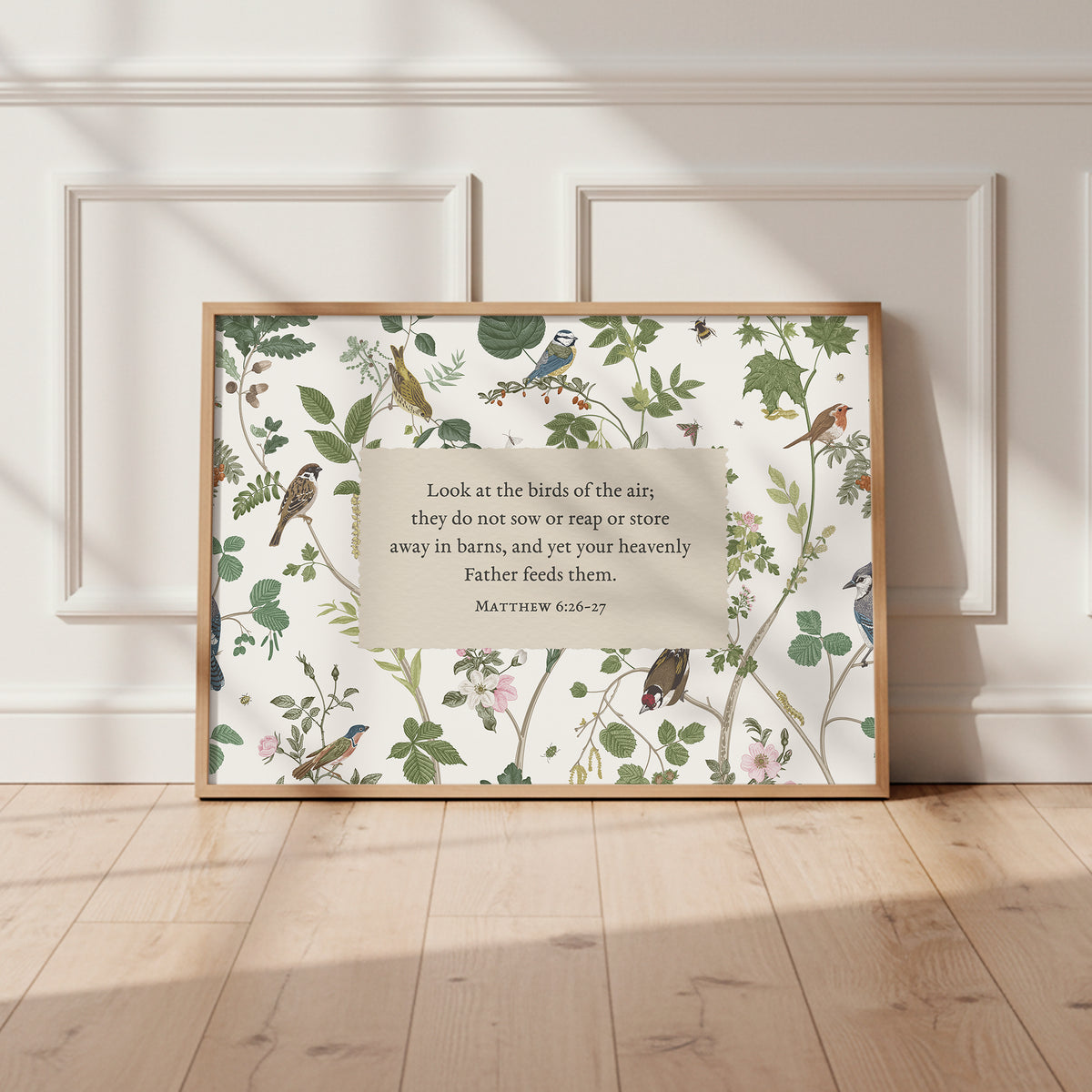 A framed poster with a floral and bird motif, featuring a Bible verse from Matthew 6:26-27.