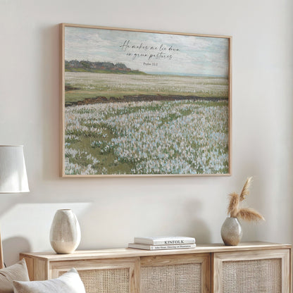 a large framed painting of a field with tall grass, hanging on a wall above a wooden cabinet with decorative items on top.